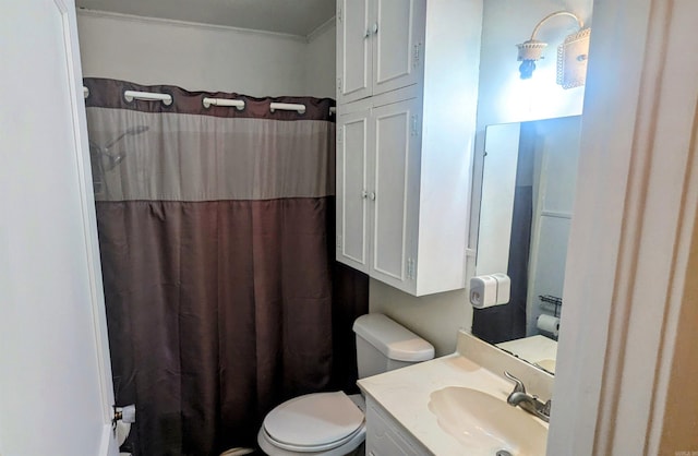 bathroom with vanity, crown molding, and toilet