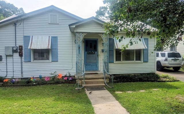 bungalow-style home with a front lawn