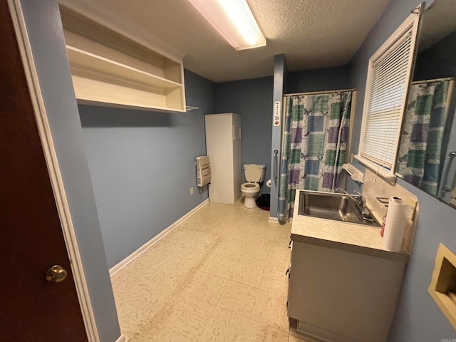 bathroom featuring a textured ceiling, vanity, toilet, and tile floors