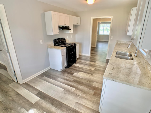 kitchen featuring white cabinets, sink, light stone countertops, light wood-type flooring, and black / electric stove