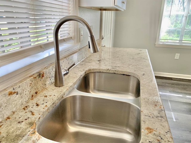 details featuring light stone countertops and sink