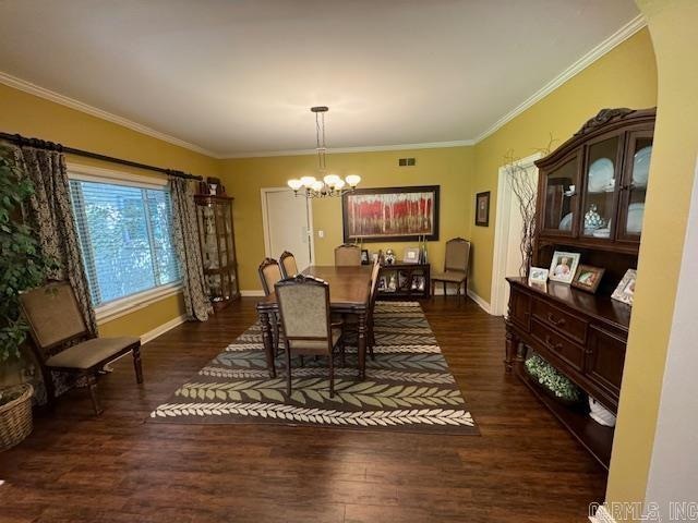 dining room featuring a notable chandelier, dark wood-type flooring, and crown molding