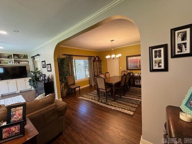 dining space with an inviting chandelier, ornamental molding, and dark hardwood / wood-style floors