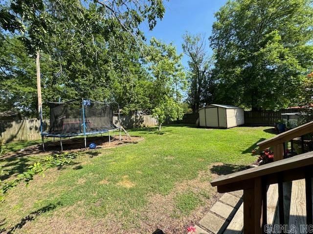 view of yard featuring a trampoline and a storage shed