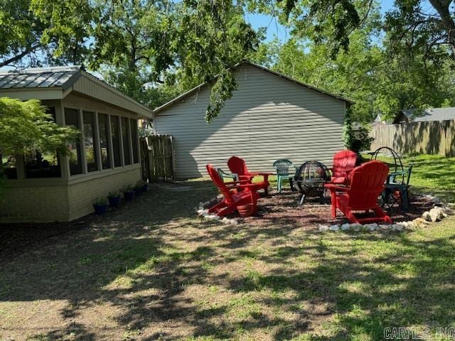 view of yard with a sunroom and an outdoor fire pit