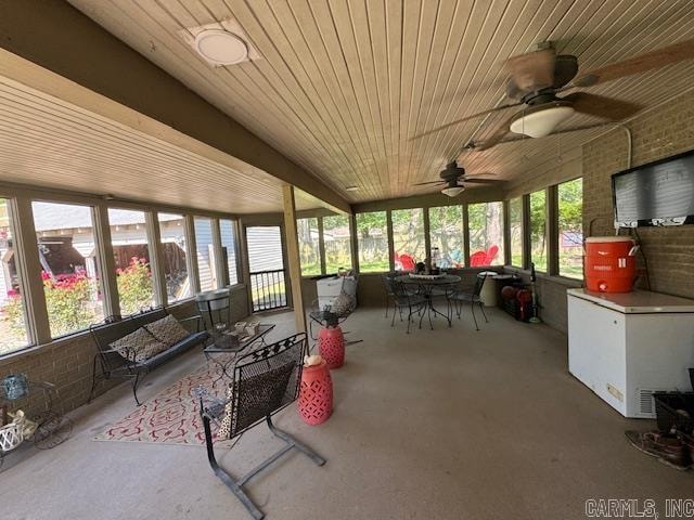 sunroom featuring ceiling fan and wood ceiling