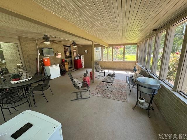 sunroom featuring a healthy amount of sunlight, wooden ceiling, and ceiling fan