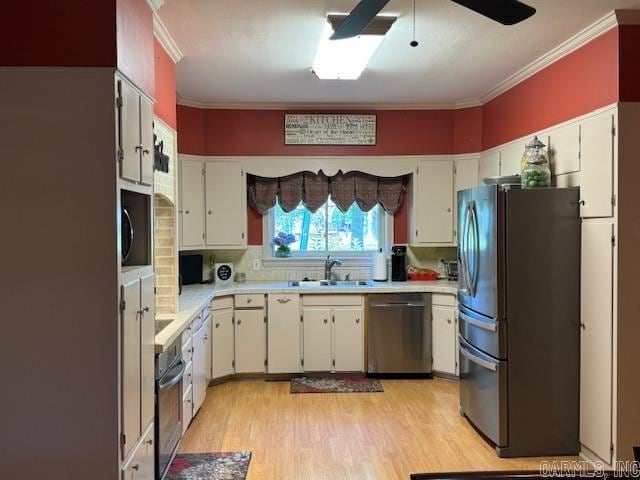 kitchen with light hardwood / wood-style floors, black appliances, sink, tasteful backsplash, and ceiling fan