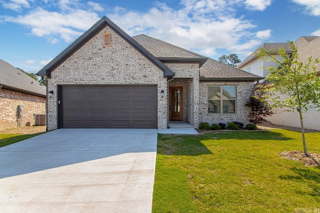 view of front of house featuring a garage, central air condition unit, and a front lawn