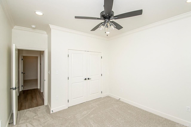 unfurnished bedroom featuring wood-type flooring, ornamental molding, ceiling fan, and a closet