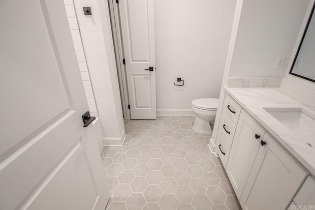 bathroom featuring tile floors, vanity, and toilet