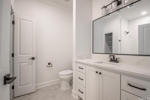 bathroom featuring tile floors, ornamental molding, vanity, and toilet