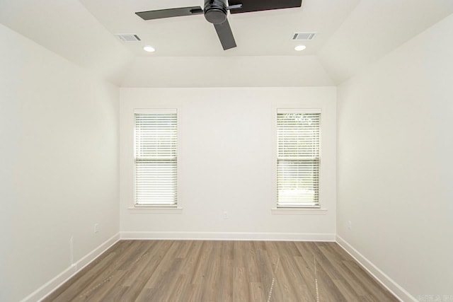 unfurnished room with a healthy amount of sunlight, wood-type flooring, and lofted ceiling