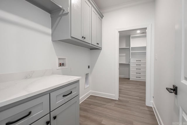 washroom featuring cabinets, crown molding, washer hookup, electric dryer hookup, and wood-type flooring