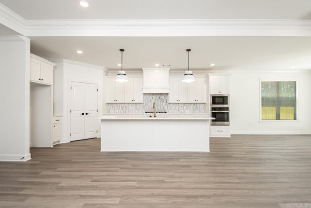 kitchen featuring stainless steel appliances, a kitchen island with sink, white cabinets, hardwood / wood-style floors, and decorative light fixtures