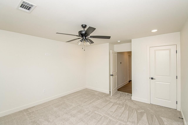 carpeted spare room featuring ceiling fan