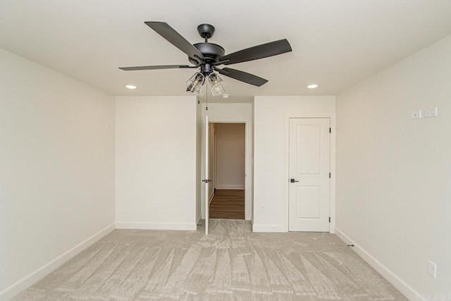 unfurnished room featuring ceiling fan and light colored carpet