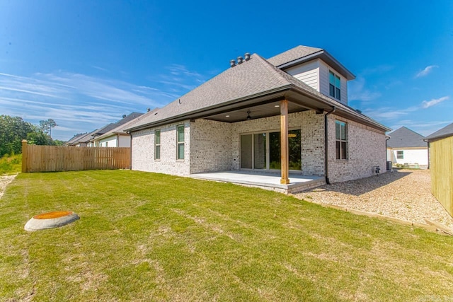 back of property with a patio area, ceiling fan, and a yard