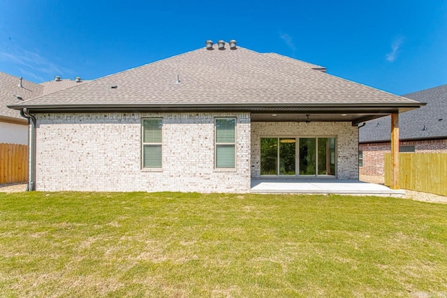 rear view of property with a yard and a patio area