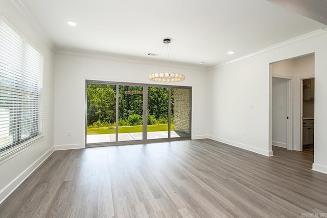 unfurnished room featuring dark hardwood / wood-style flooring, crown molding, and a chandelier