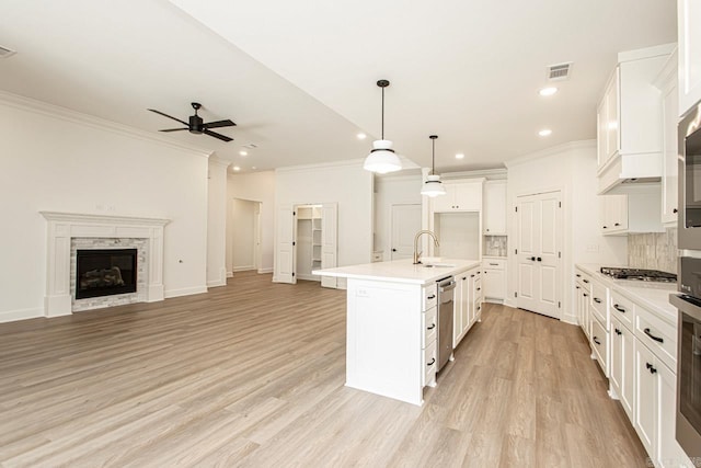 kitchen featuring light hardwood / wood-style floors, white cabinetry, an island with sink, sink, and ceiling fan