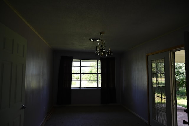 carpeted empty room featuring an inviting chandelier