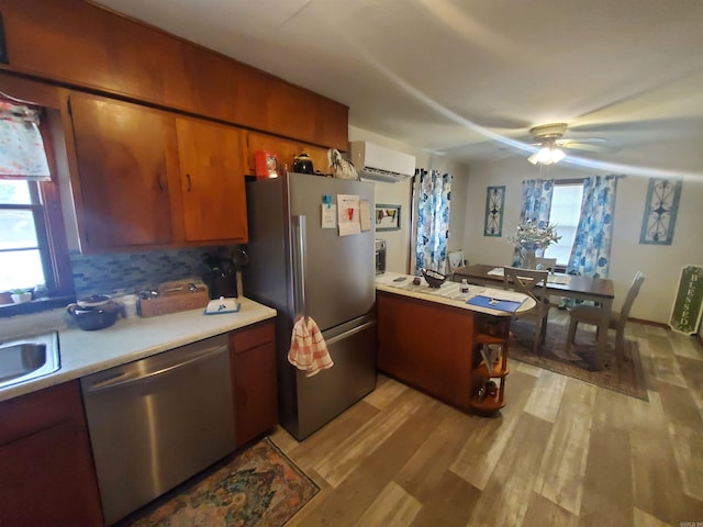 508 State St, Greenway, AR 72430 - kitchen featuring appliances with stainless steel finishes, a wall mounted air conditioner, light countertops, light wood-type flooring, and a peninsula