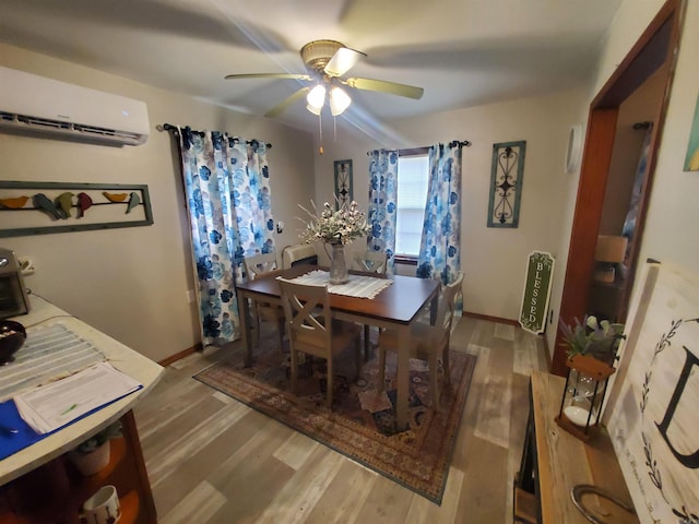 508 State St, Greenway, AR 72430 - dining room with an AC wall unit, wood finished floors, a ceiling fan, and baseboards