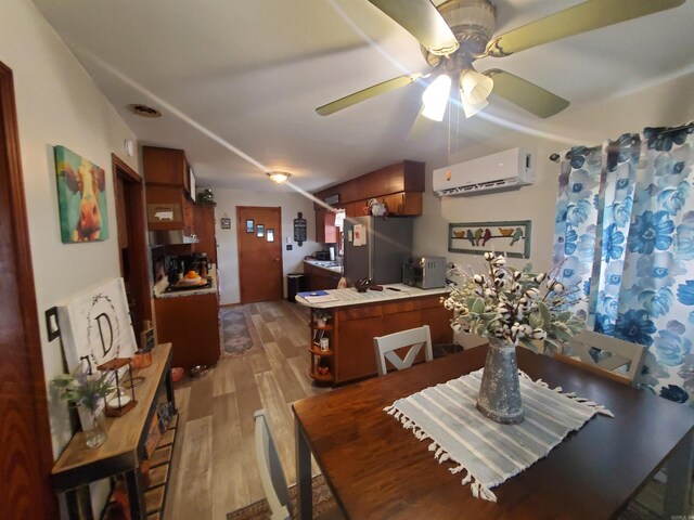 508 State St, Greenway, AR 72430 - dining area featuring a wall unit AC, light wood-style floors, and a ceiling fan