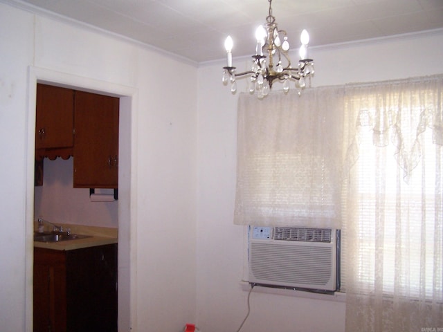 kitchen featuring plenty of natural light, decorative light fixtures, a chandelier, sink, and ornamental molding