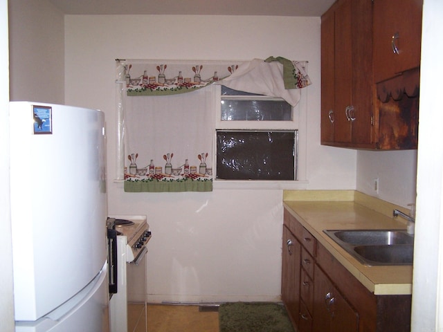 kitchen featuring sink, white refrigerator, light tile flooring, and stove