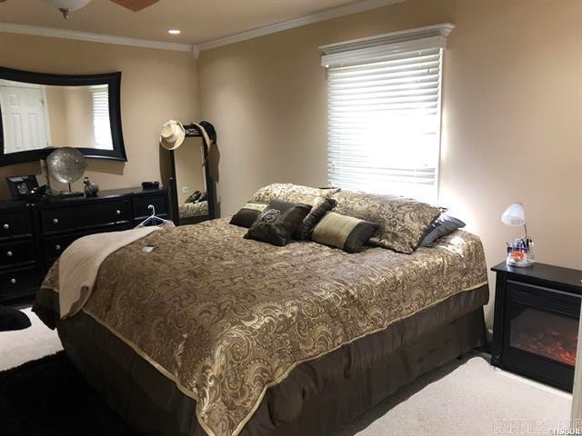 bedroom with multiple windows, carpet, and ornamental molding