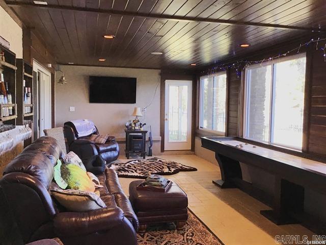 game room featuring wood ceiling and a wood stove