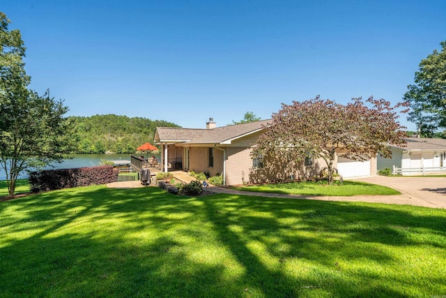 view of front of house with a garage, a water view, and a front yard