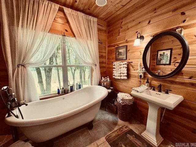 bathroom with wood walls, tile flooring, and a bathtub