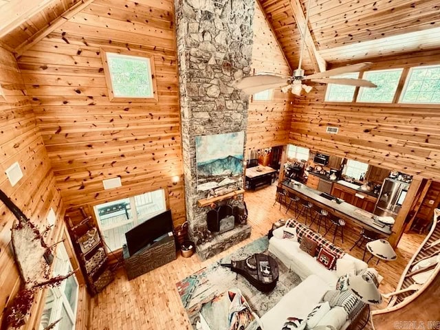 living room featuring hardwood / wood-style floors, wooden walls, beam ceiling, and wood ceiling