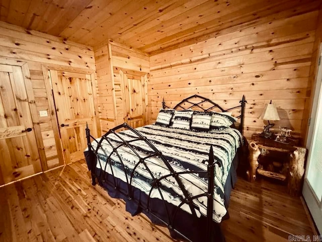 bedroom with wooden walls, hardwood / wood-style flooring, and wood ceiling