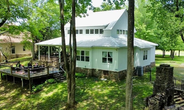 rear view of house with a yard, a deck, and central air condition unit