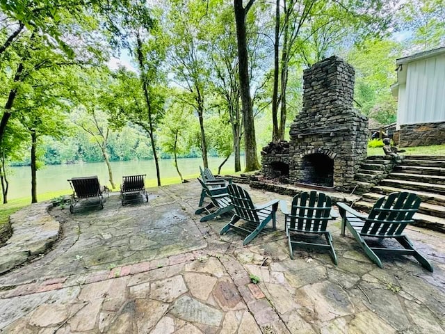 view of terrace featuring an outdoor stone fireplace