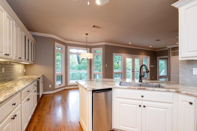 kitchen featuring crown molding, tasteful backsplash, dishwasher, light wood-type flooring, and hanging light fixtures