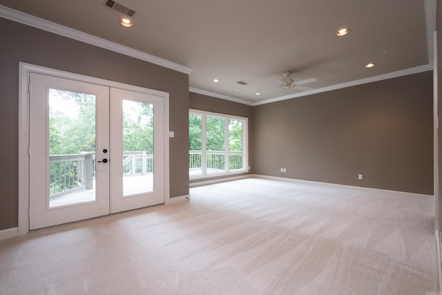 carpeted spare room featuring french doors, ornamental molding, and ceiling fan