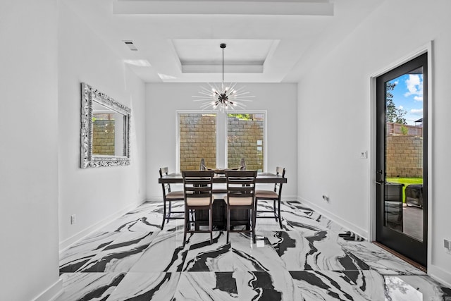 dining space with a tray ceiling and a notable chandelier