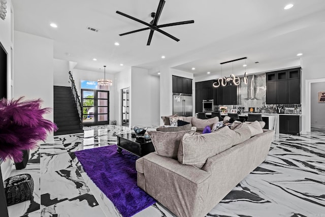 living room featuring ceiling fan with notable chandelier