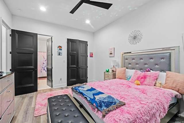 bedroom featuring connected bathroom, ceiling fan, and light hardwood / wood-style flooring