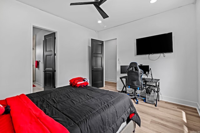 bedroom with ensuite bathroom, light hardwood / wood-style flooring, and ceiling fan