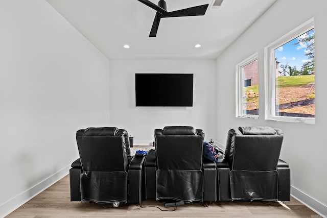 home theater room featuring light wood-type flooring and ceiling fan