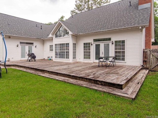 rear view of property with a deck, a yard, and french doors