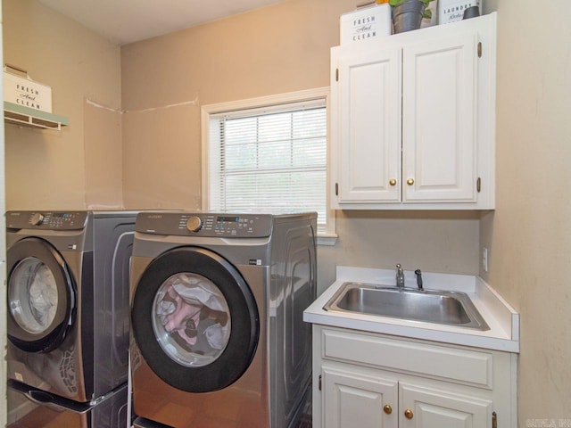 laundry area featuring washer and clothes dryer, cabinets, and sink