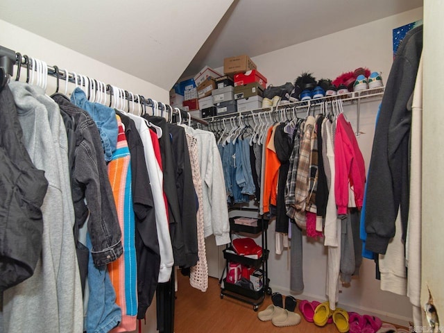 walk in closet featuring hardwood / wood-style flooring and lofted ceiling