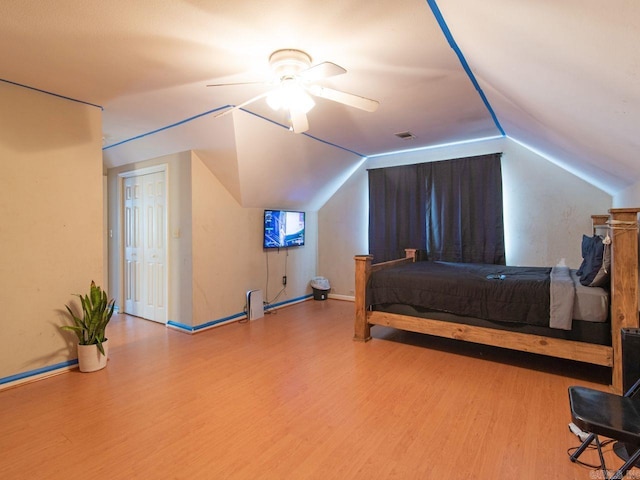 bedroom with ceiling fan, vaulted ceiling, and hardwood / wood-style flooring